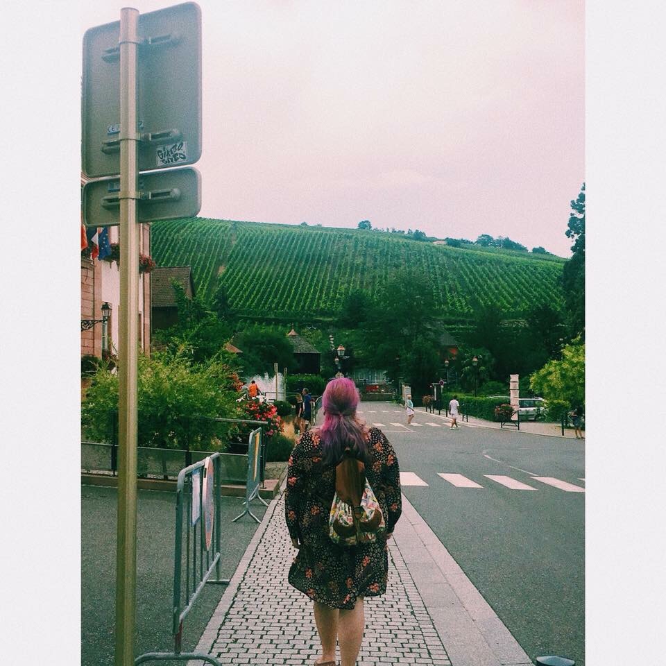pink hair girl from being in riquewihr france wine road and wine yards and growing grapes around, vyno kelyje prancuzijoje