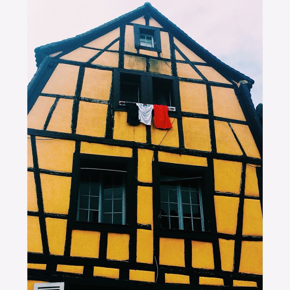 alsace building and french flag made from shirts from the window, vyno kelyje prancuzijoje veliava ir kolmaras